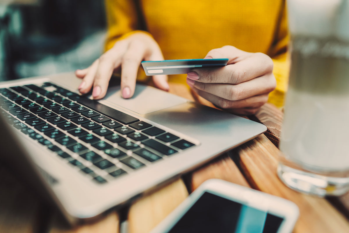 Woman's hands holding credit card and typing on keyboard on laptop